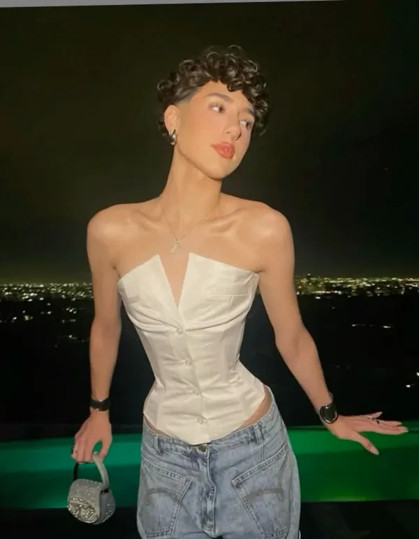 Woman in corset top and jeans with city nightscape