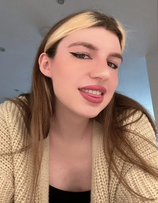 Close-up selfie with beige cardigan over black top