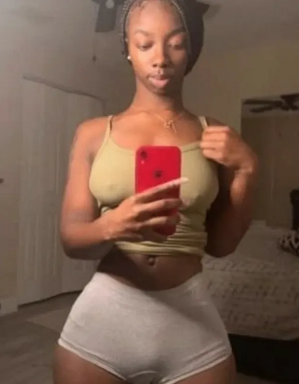 Woman in patterned top and black skirt indoors