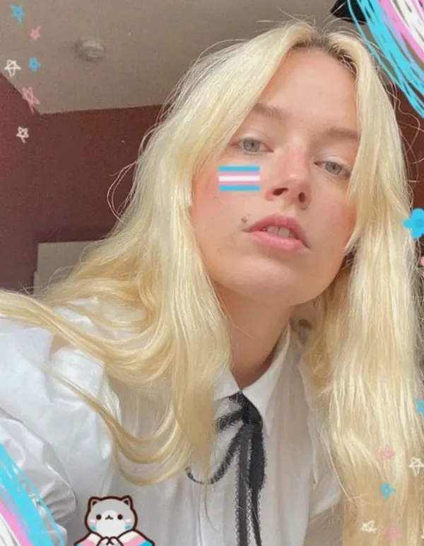 Close-up indoor selfie in fitted white long-sleeve top