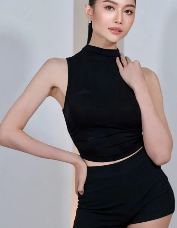 Woman in black sleeveless crop top and shorts in studio