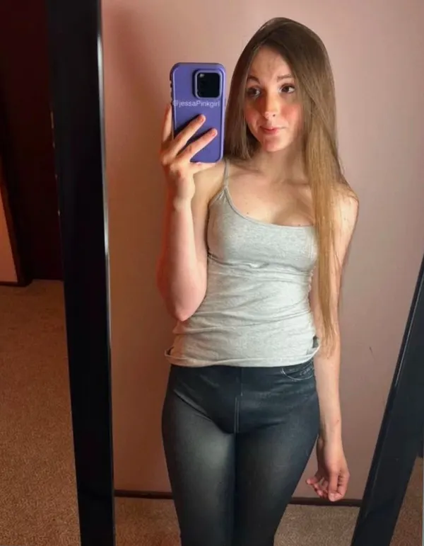Woman in gray tank top and leggings mirror selfie