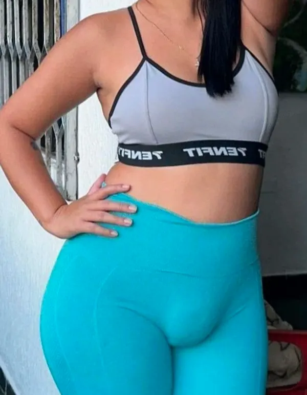 Woman in gray sports bra and blue leggings indoors